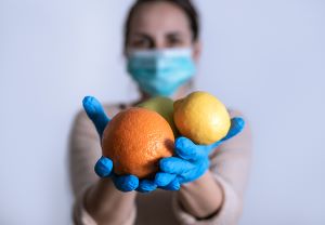 bigstock woman with mask holding fruit 359231101